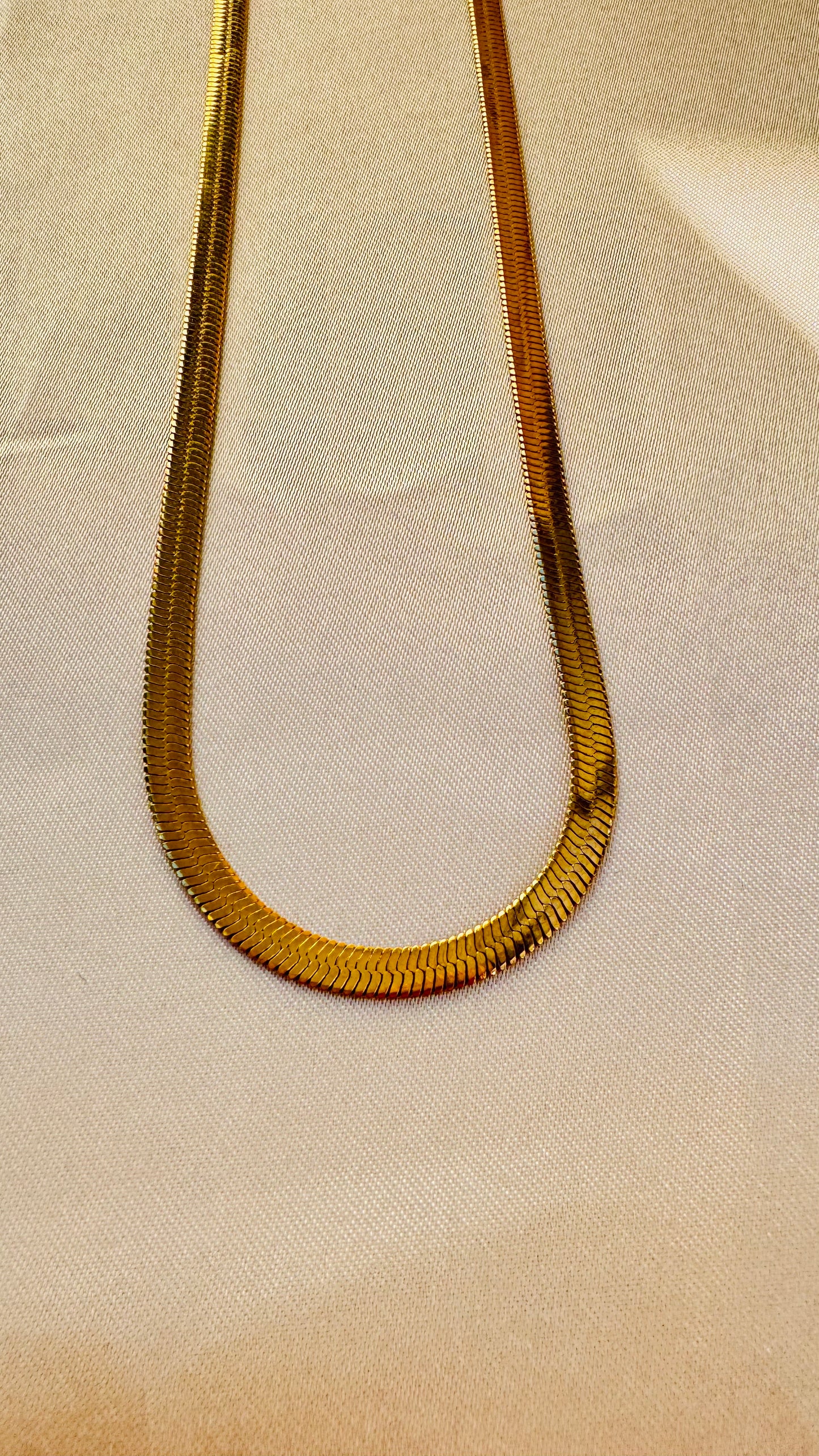 Snake chain on a beige fabric background