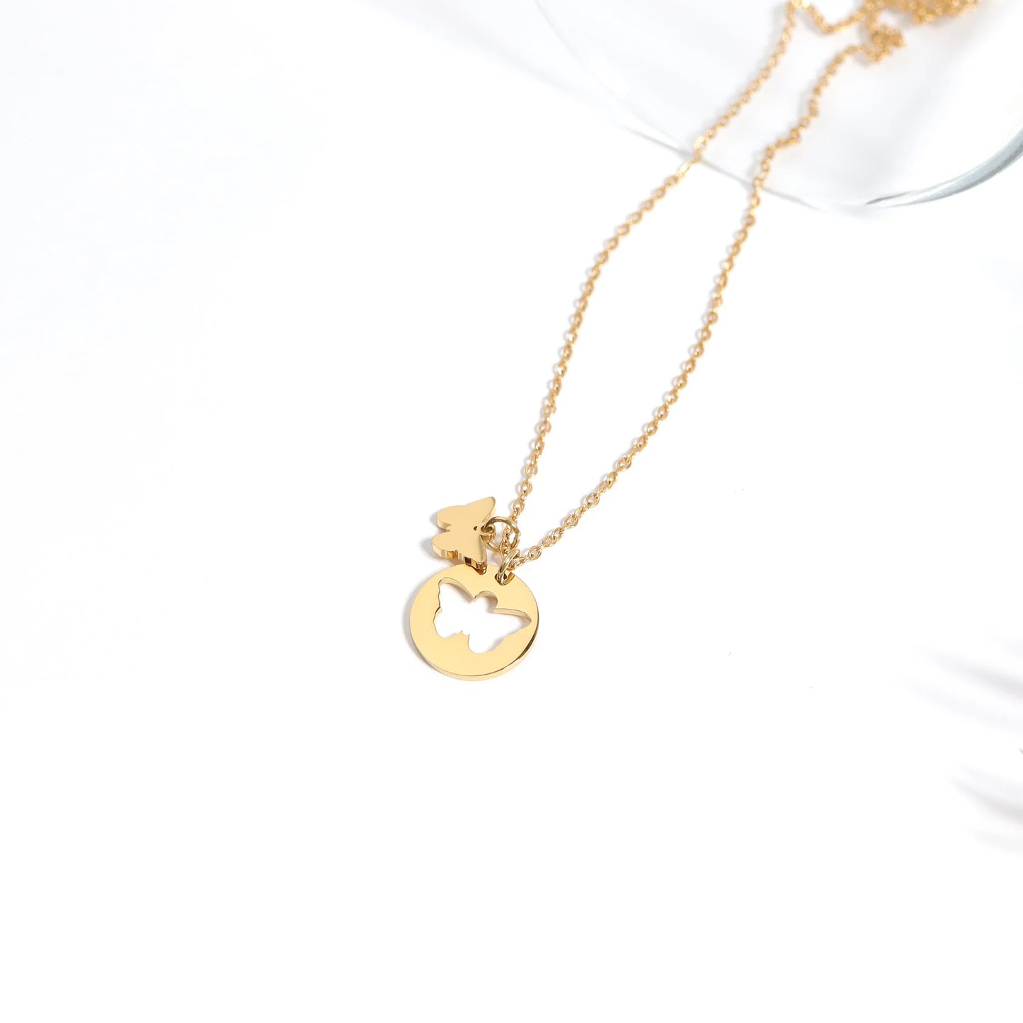 Gold necklace with a heart-shaped pendant on a white background