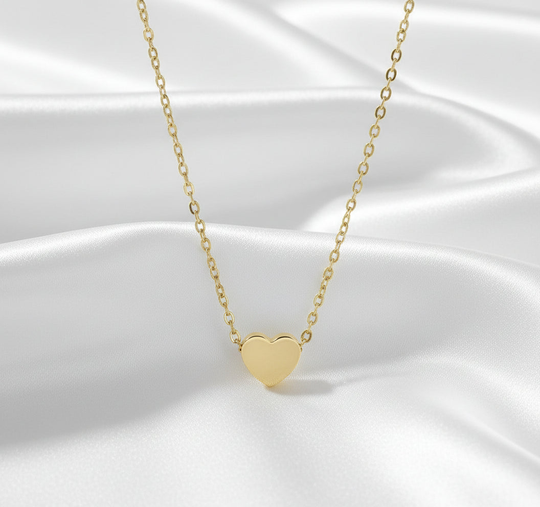 Gold heart-shaped necklace on a white background