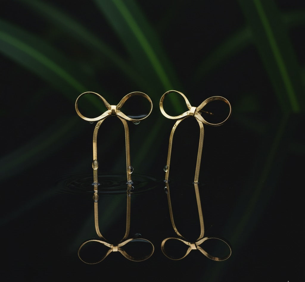 Pair of gold eyeglasses on a reflective surface with a dark background