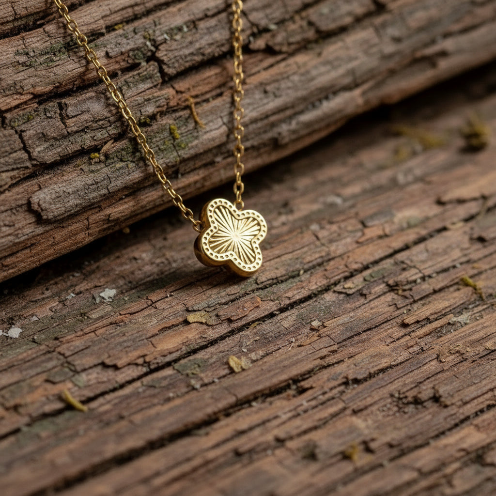 clover necklace on a textured surface with flowers in the background