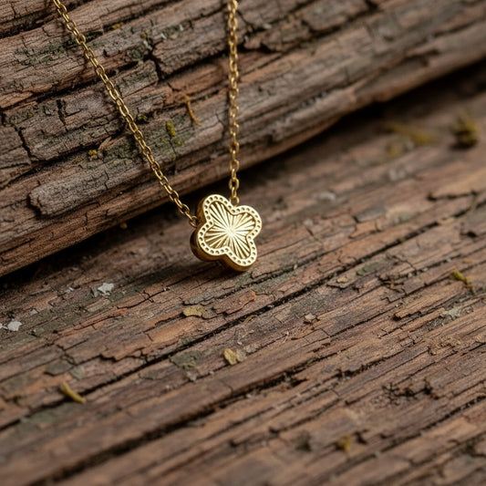 clover necklace on a textured surface with flowers in the background