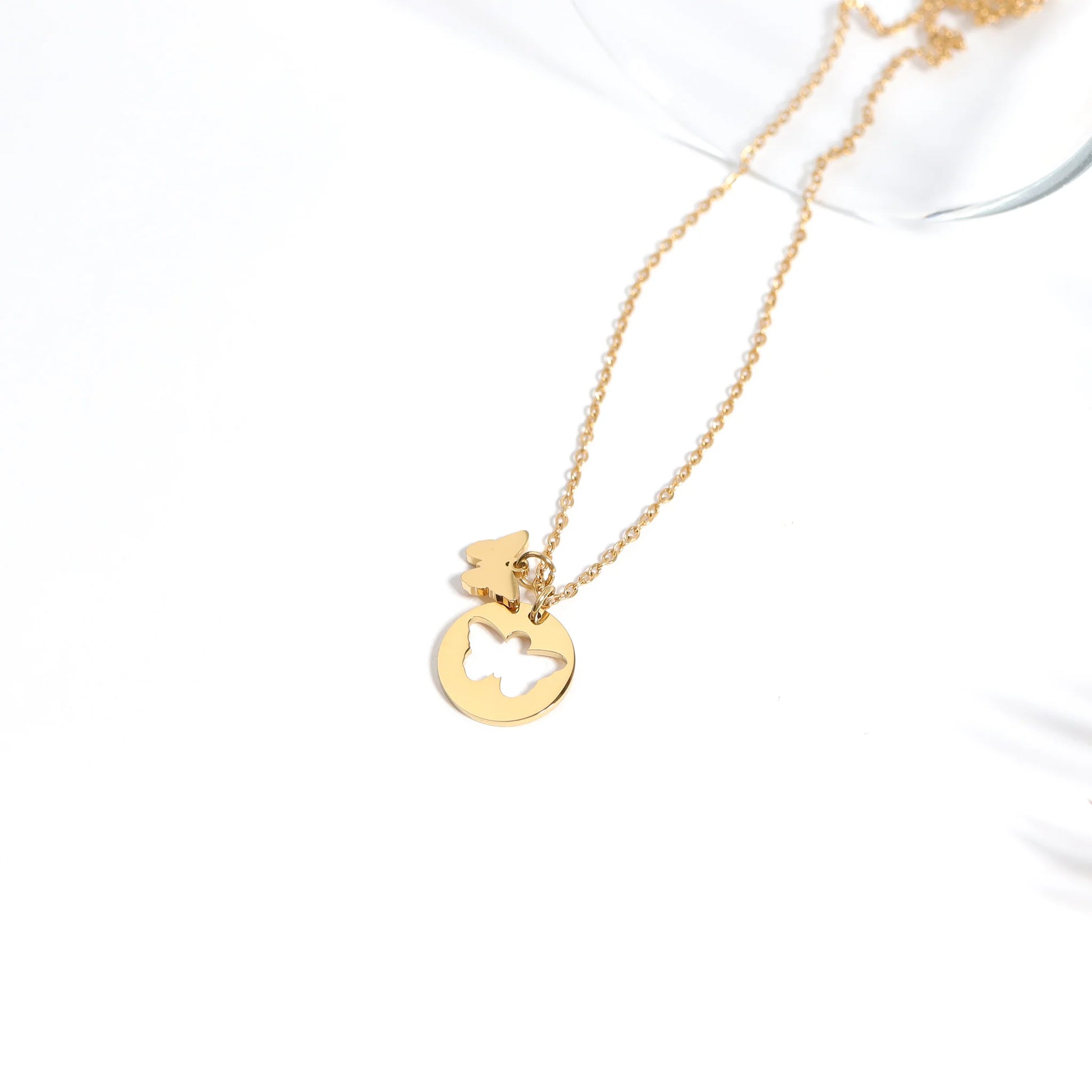 Gold necklace with a heart-shaped pendant on a white background