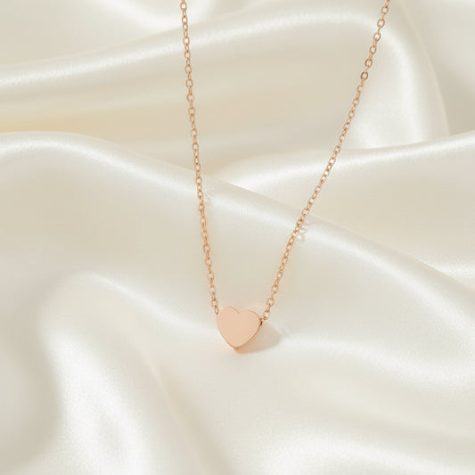 Rose gold heart-shaped pendant necklace on a white background
