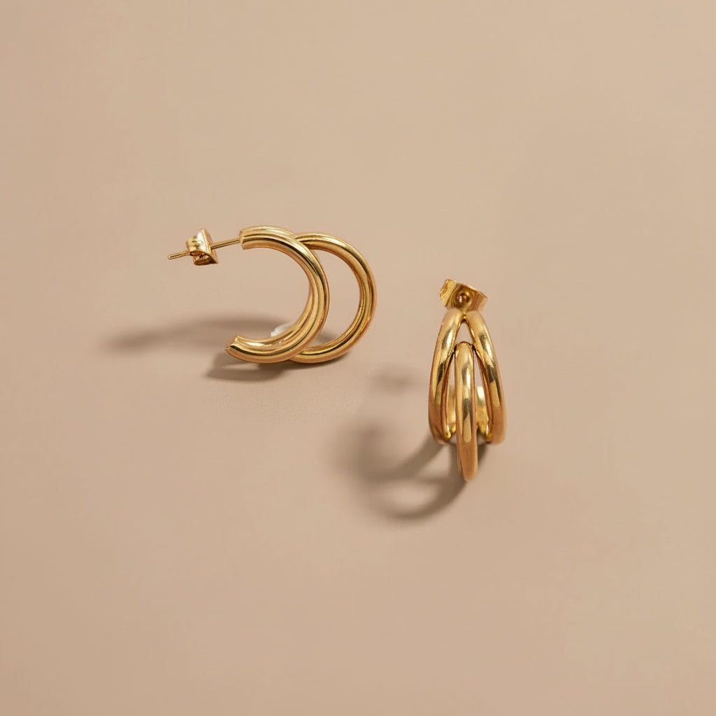 huggie hoop earrings on a pink background