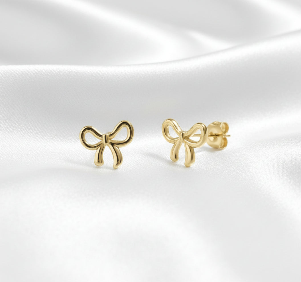 Gold bow-shaped earrings on a white background
