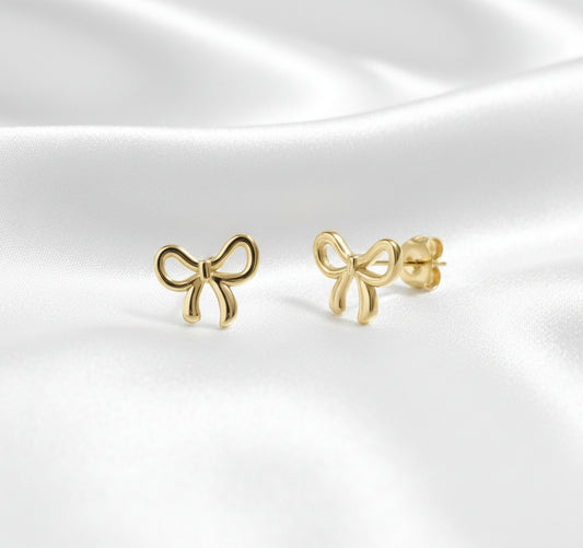 Gold bow-shaped earrings on a white background
